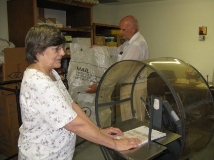 Judy is tying the magazines and Clay is getting the mail bag ready